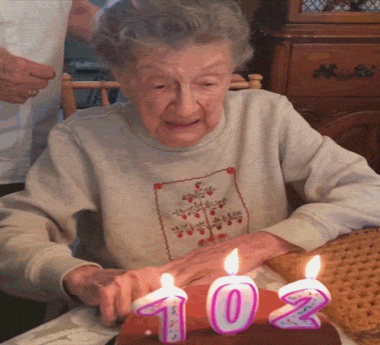 Old grandma blowing candles on a cake teeth falling out