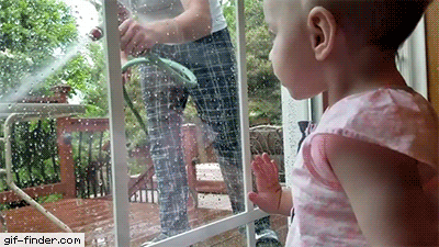 baby scared of a water hose through window glass